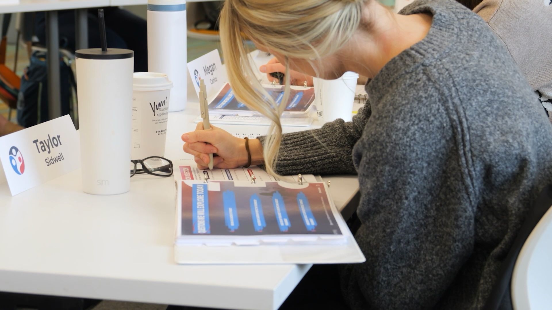 Blonde haired woman writing in a workbook
